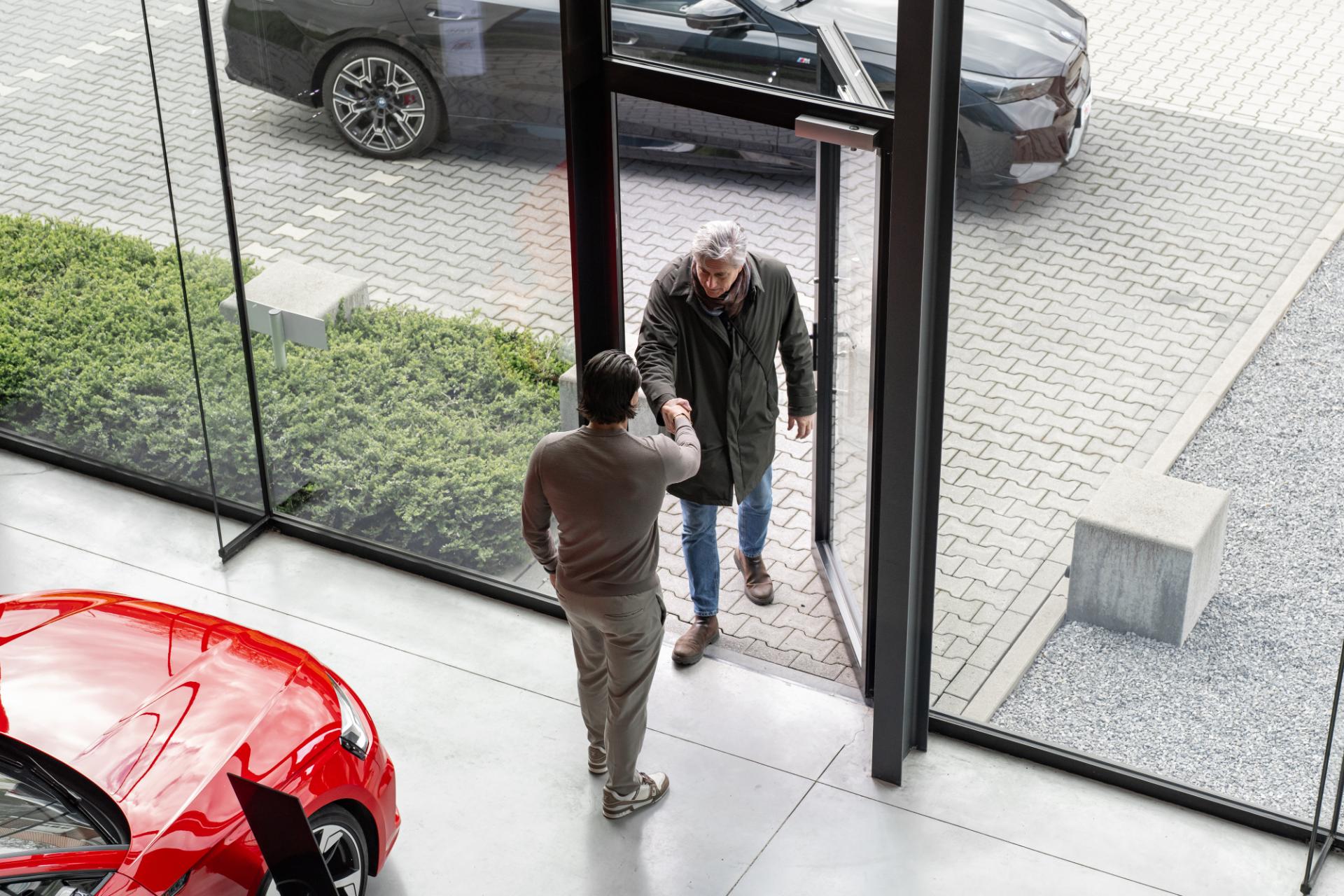 Klant wordt ontvangen met handdruk in showroom	