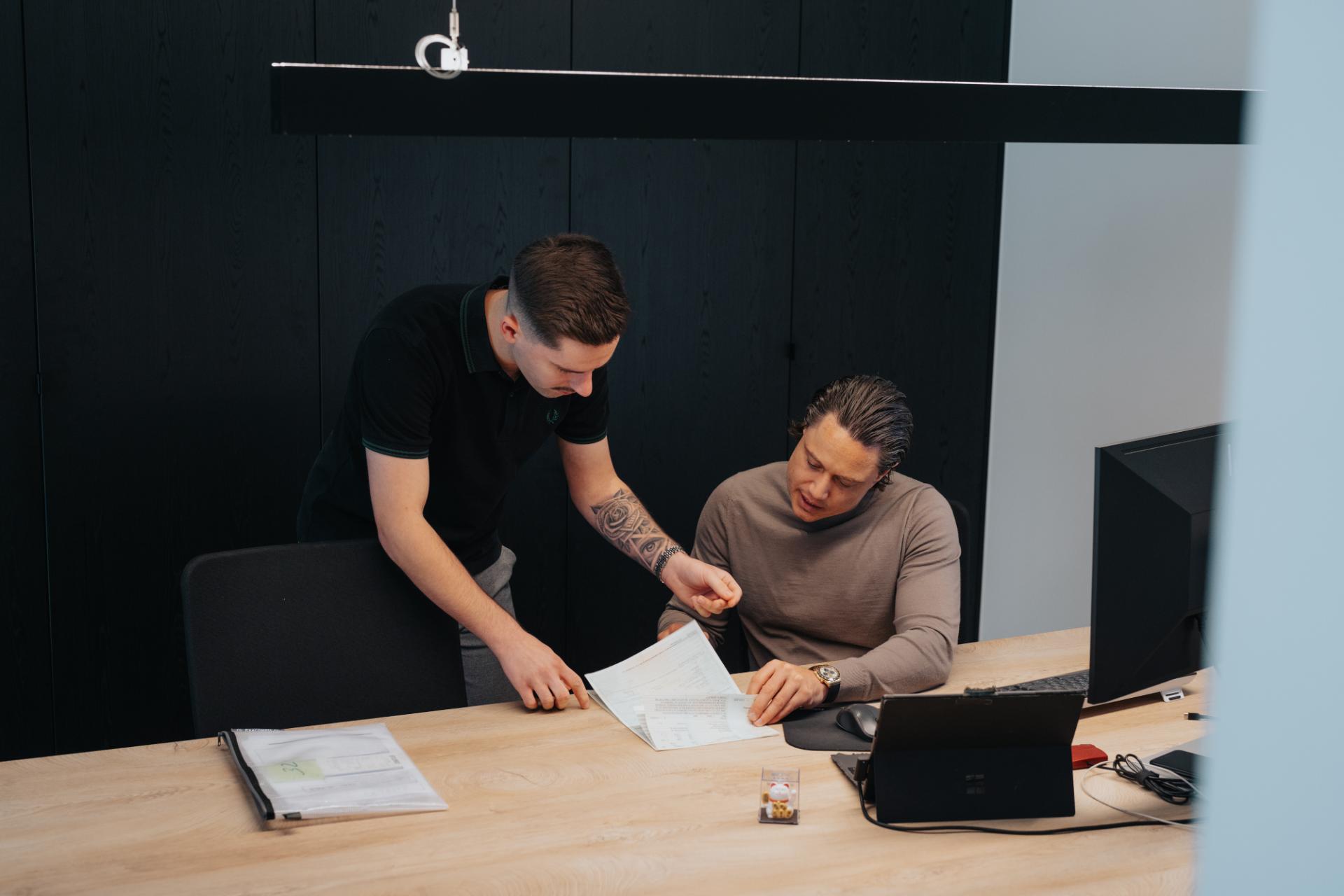 Medewerkers van Trex Cars bespreken de btw- en BPM-documenten bij een auto-import uit Nederland